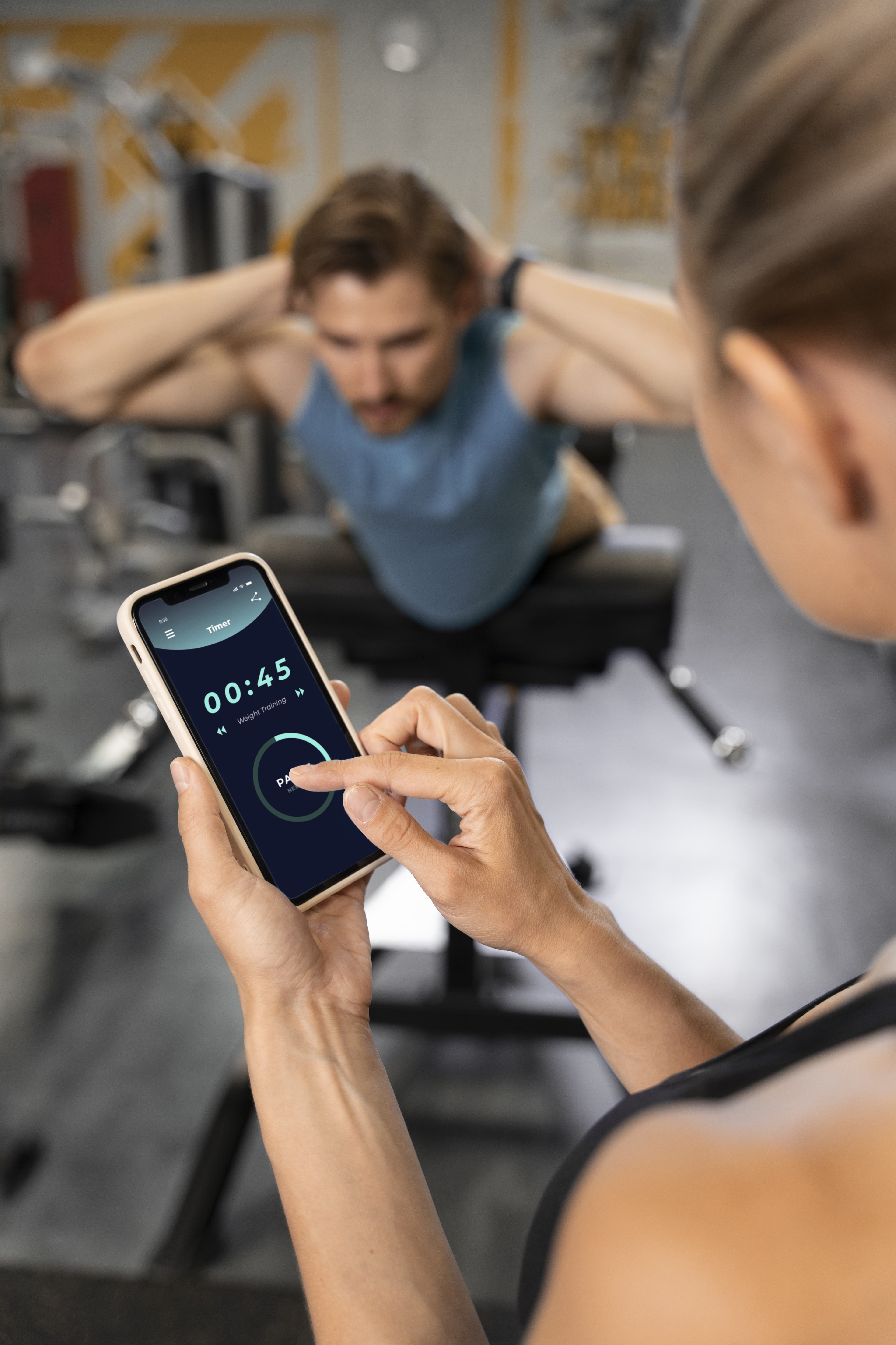 Trainer hilft einem Mitglied im Fitnessstudio